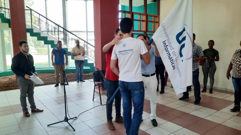 El estudiante Víctor Santos Oliva recibió la bandera de la UCI de manos del Rector y del Primer Secretario del Comité de la UJC en La Habana.