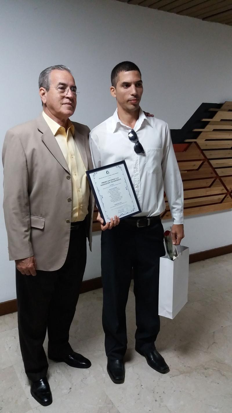 Momento en que el Dr.C. José Ramón Saborido Loide, titular del MES, entregó el Premio Nacional a la Innovación Tecnológica, otorgado por el Citma a Ceige, al ingeniero Raymond Weeden Gamboa, arquitecto principal de Gina. 