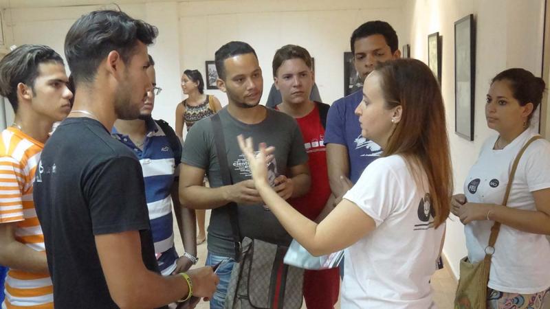 Presidenta nacional de la FEU, Jennifer Bello Martínez, dialoga con estudiantes de la UCI durante la muestra fotográfica en homenaje al Che, en el Aniversario 89 de su natalicio. 