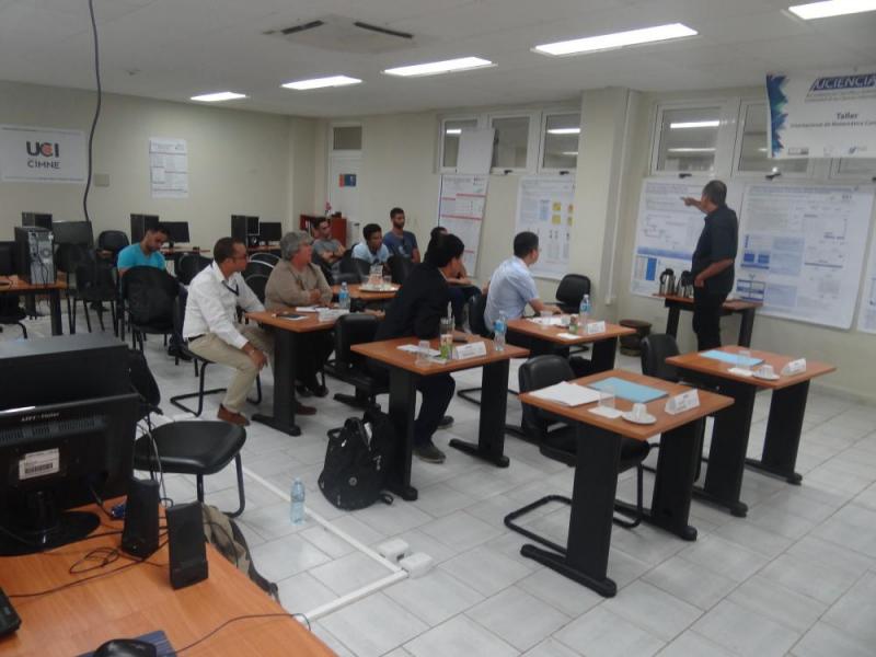 El profesor auxiliar Ing. Edisel Navas Conyedo, explica a los visitantes los pósteres de proyectos ejecutados por el Centro de Matemática Computacional de la UCI.