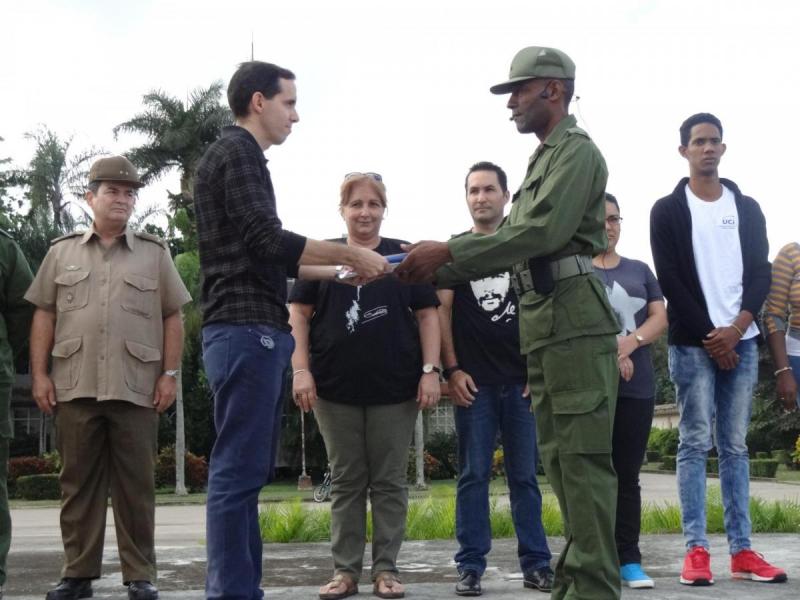 Después de recibir de manos de los decanos de las facultades los libros con el compromiso de los estudiantes de primer año a su incorporación a las MTT, el teniente coronel Filiberto Ángel Blanco, profesor del Departamento de Enseñanza Militar, se los entregó al vicerrector Primero de la UCI, Dr.C. Raydel Montesino. 