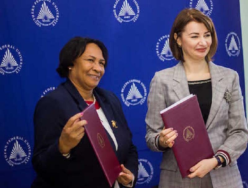 University presidents exchange signed copies of the agreement